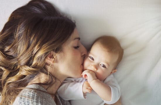a postpartum woman kissing her baby benefiting from pelvic health physical therapy