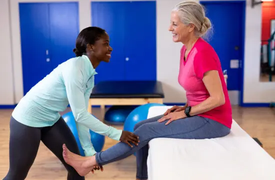 physical therapist holding a patient's leg after total knee replacement surgery